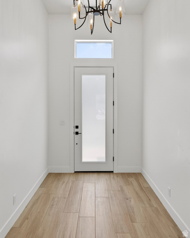 2862 South Mountain Rnch Road Cedar City, UT 84720 - Photo 4 of 64 Entryway featuring a contemporary chandelier, transom window, and wood-finish tile flooring