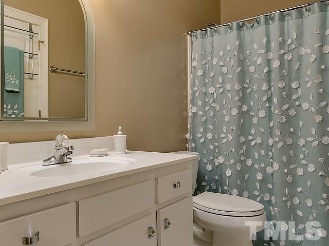 7905 Ogden Court Raleigh, NC 27613 - Photo 22 of 25 a bathroom with a sink a toilet and a mirror