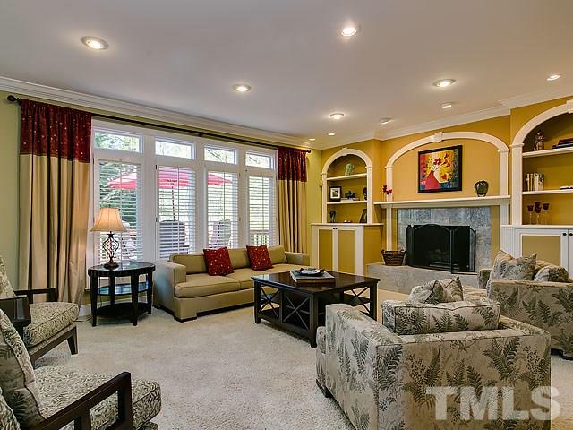 7905 Ogden Court Raleigh, NC 27613 - Photo 10 of 25 a living room with furniture ceiling fan and a fireplace