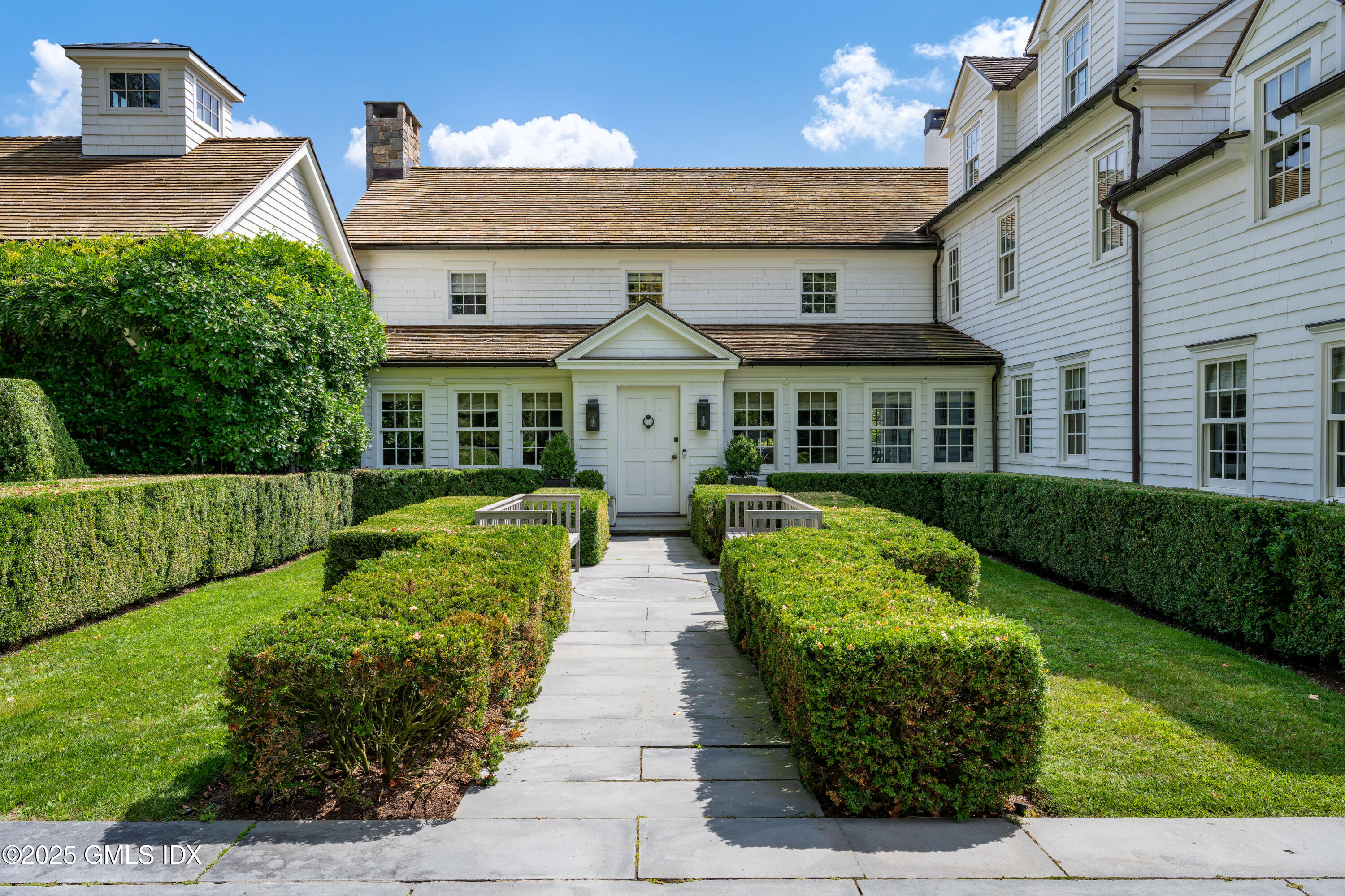 411 Stanwich Road Greenwich, CT 06830 - Photo 7 of 36 a front view of a house with a garden and plants
