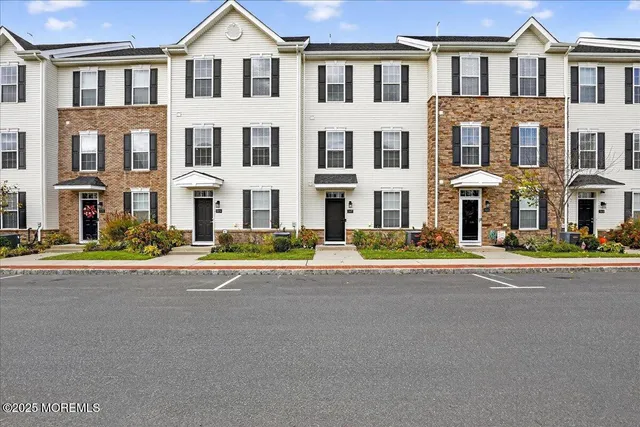 front view of a brick house with a yard