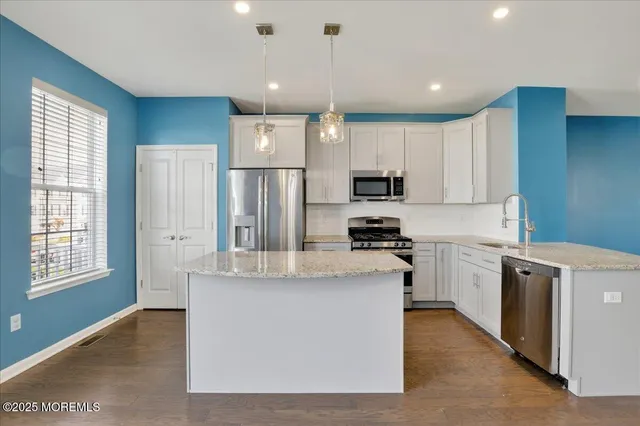 a kitchen with stainless steel appliances granite countertop a refrigerator oven a sink dishwasher and a refrigerator