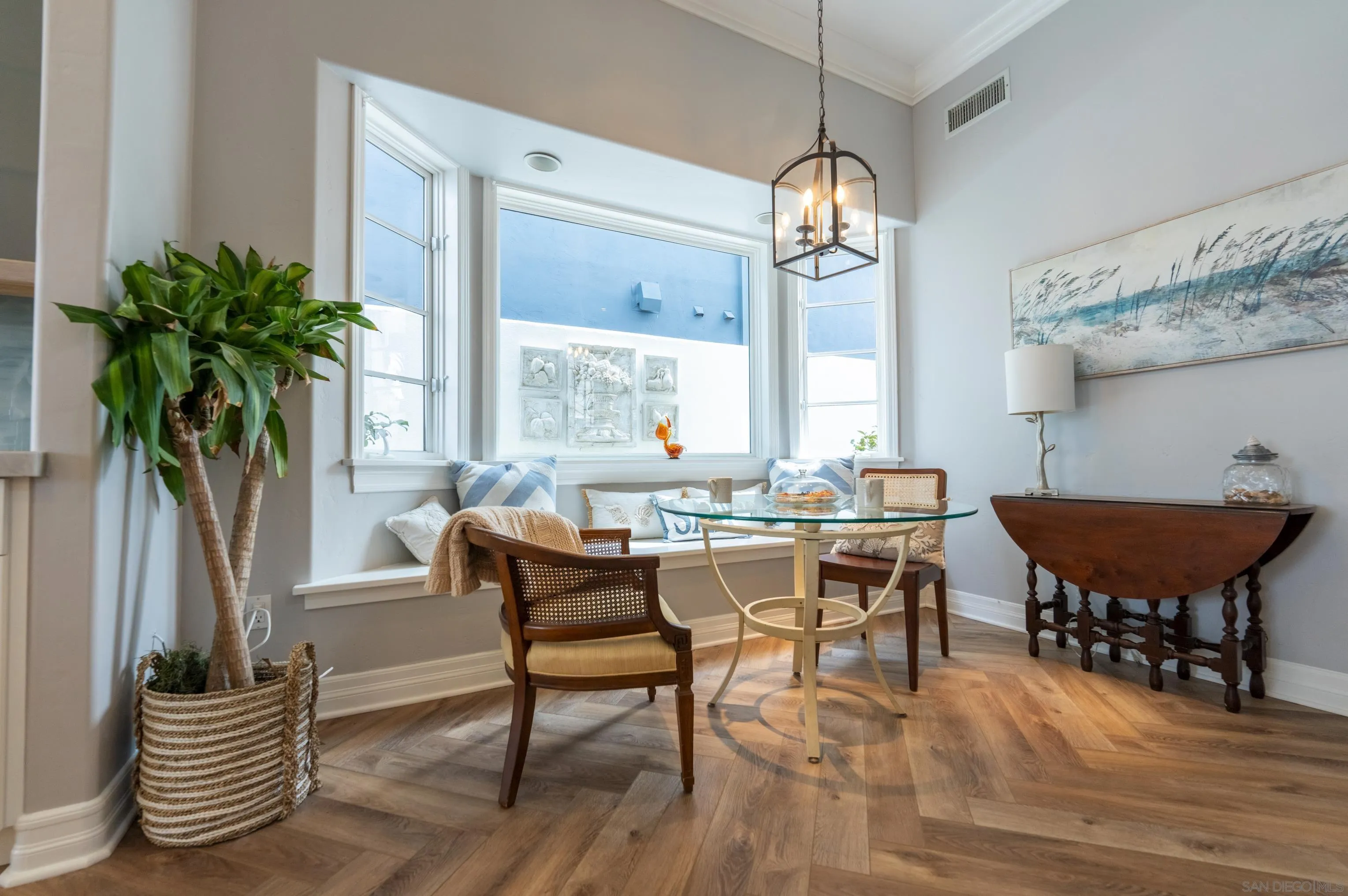 29 The Point Coronado, CA 92118 - Photo 17 of 52 a dining room with furniture a chandelier and wooden floor