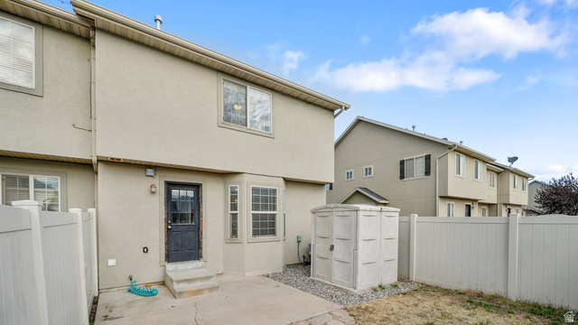 983 South 1850th Street West Springville, UT 84663 - Photo 18 of 30 Rear exterior featuring a stucco finish, ground-level patio, and a utility storage shed