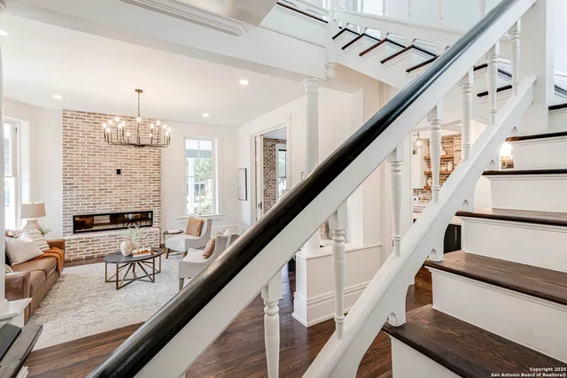 a living room with furniture a chandelier a fireplace and a window