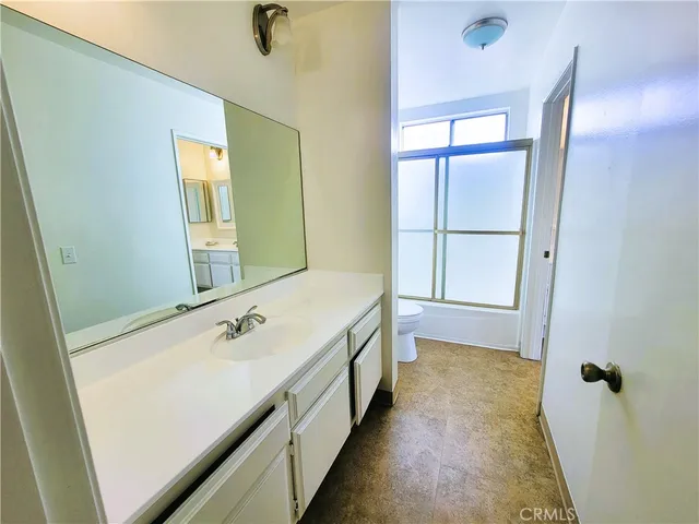 a bathroom with a double vanity sink a mirror and a bathtub