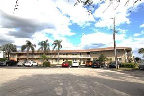 298 Southeast 6th Avenue, Unit 9 Pompano Beach, FL 33060 - Photo 19 of 22 a city street lined with parked cars and buildings