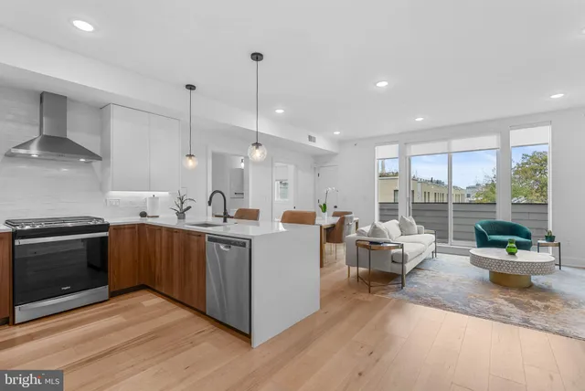 a large kitchen with kitchen island a large counter top space a sink a stove and wooden floor