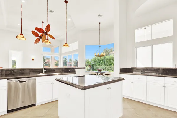 a kitchen with stainless steel appliances granite countertop a sink a stove and a refrigerator