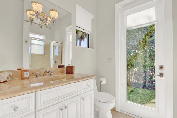 a spacious bedroom with a bed flat screen tv and a large window