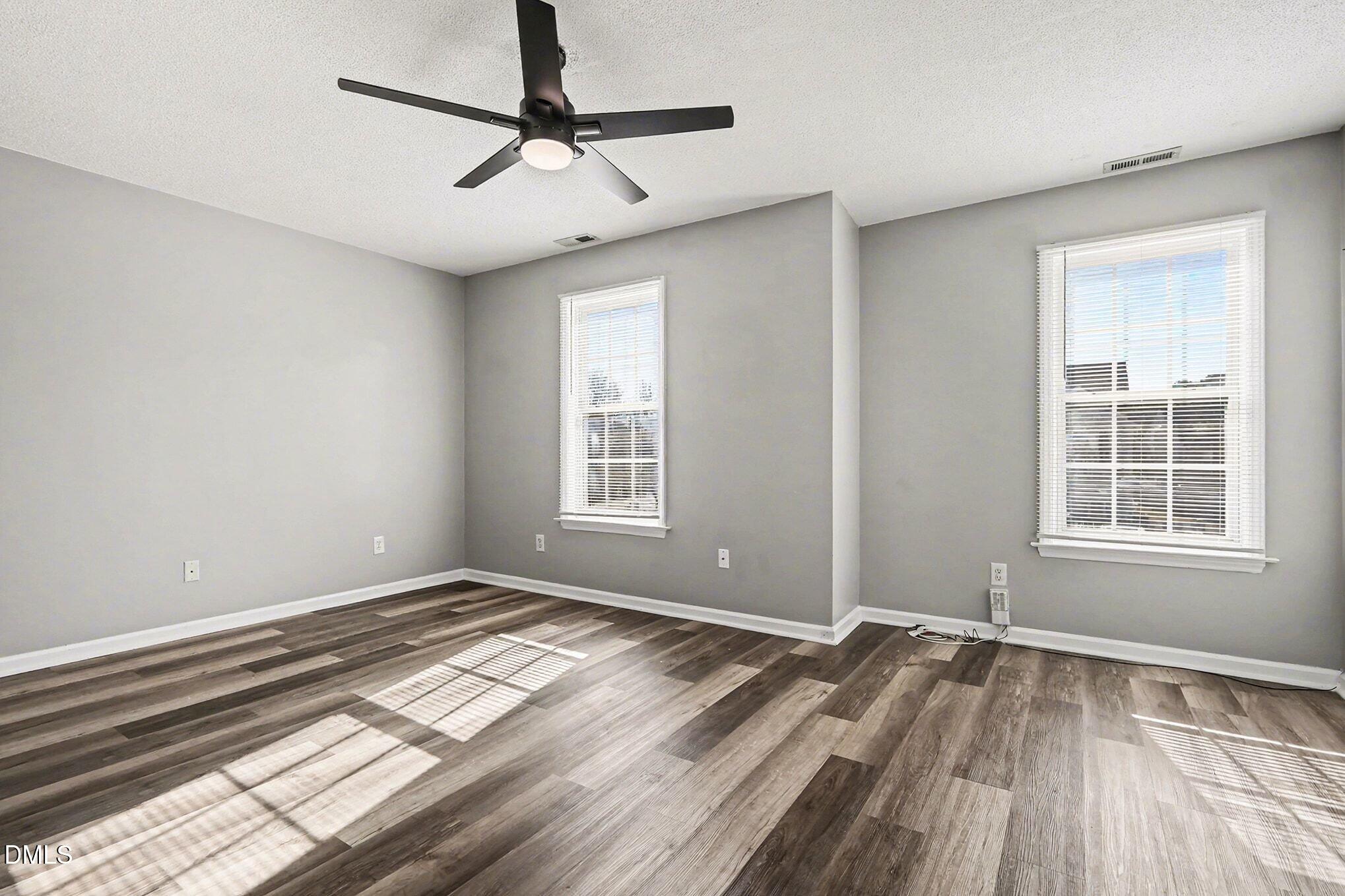 5121 Jimmy Ridge Place Raleigh, NC 27610 - Photo 11 of 18 a view of empty room with wooden floor and fan