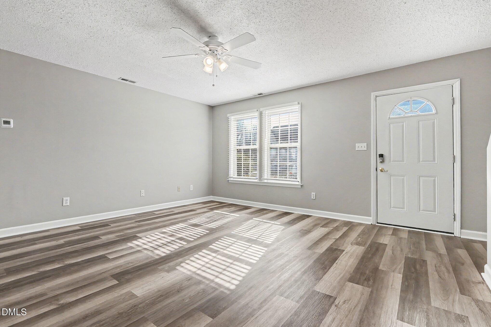 5121 Jimmy Ridge Place Raleigh, NC 27610 - Photo 3 of 18 a view of an empty room with wooden floor and a window