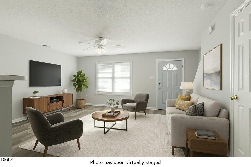 5121 Jimmy Ridge Place Raleigh, NC 27610 - Photo 5 of 18 a living room with furniture a flat screen tv and a window