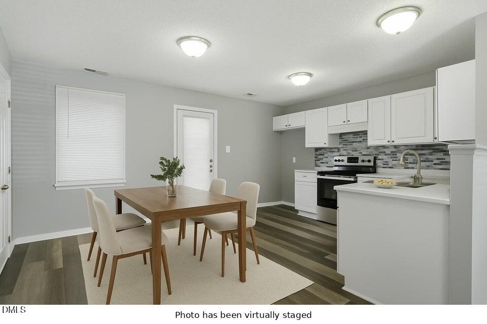 5121 Jimmy Ridge Place Raleigh, NC 27610 - Photo 9 of 18 a kitchen with stainless steel appliances kitchen island granite countertop a table chairs sink and cabinets
