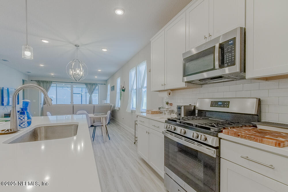 3616 Cunningham Road Orange Park, FL 32065 - Photo 11 of 48 a kitchen with stainless steel appliances a stove a sink and a microwave