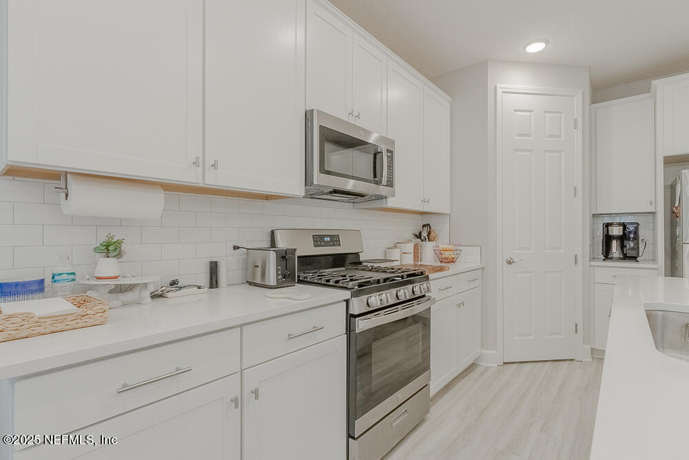 3616 Cunningham Road Orange Park, FL 32065 - Photo 12 of 48 a kitchen with stainless steel appliances granite countertop grey cabinets a stove a sink and a refrigerator