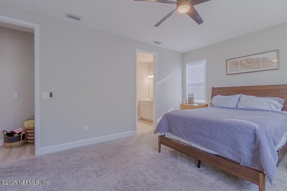 3616 Cunningham Road Orange Park, FL 32065 - Photo 21 of 48 a bedroom with a bed and a chandelier