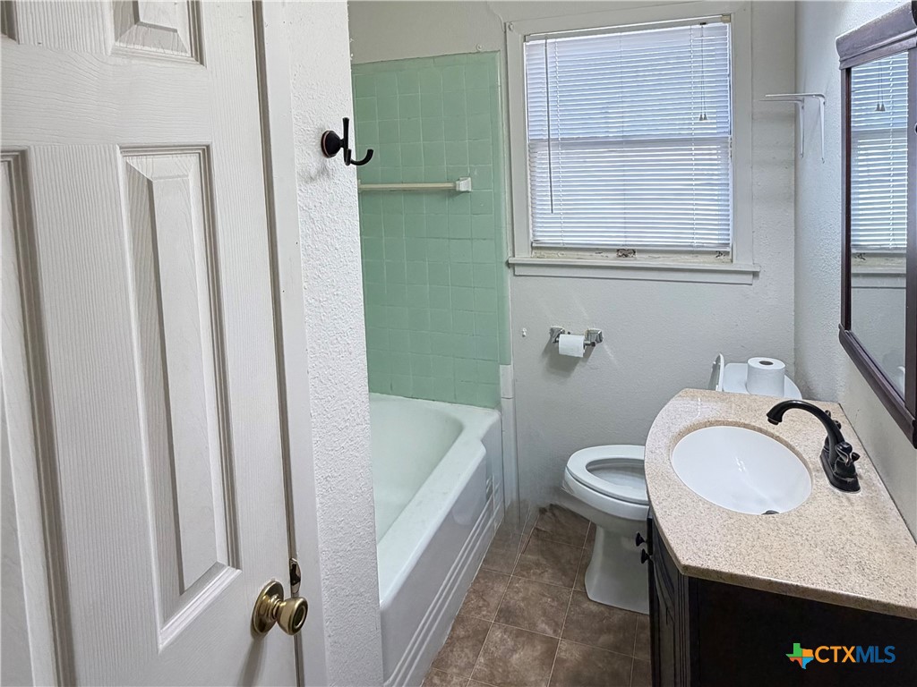1902 Navidad Street Victoria, TX 77901 - Photo 21 of 23 a bathroom with a sink a toilet and a mirror