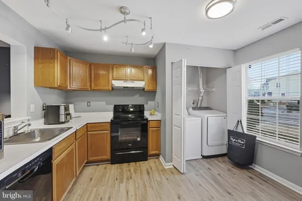a kitchen with a sink appliances cabinets and a window