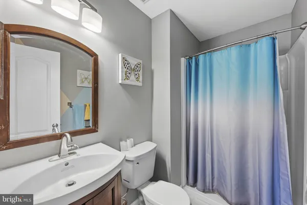 a bathroom with a toilet a sink and mirror