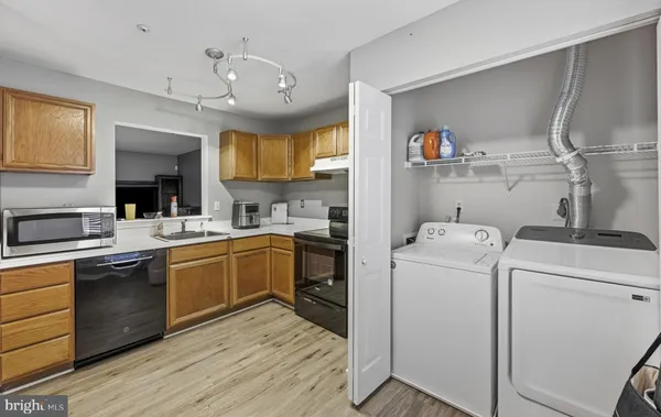 a kitchen that has a lot of cabinets in it and wooden floors