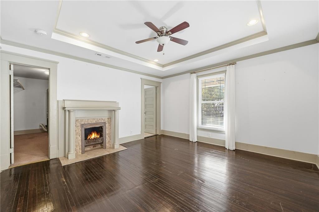 1530 South Gordon Street Southwest Atlanta, GA 30310 - Photo 27 of 46 an empty room with wooden floor a ceiling fan a fireplace and windows