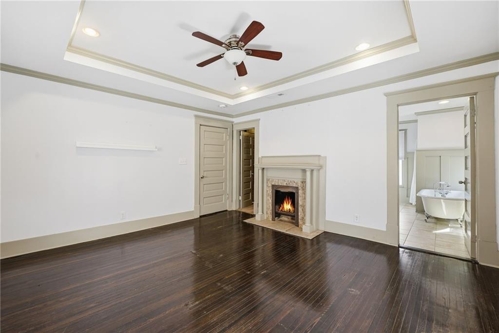 1530 South Gordon Street Southwest Atlanta, GA 30310 - Photo 29 of 46 an empty room with wooden floor a ceiling fan a fireplace and a window