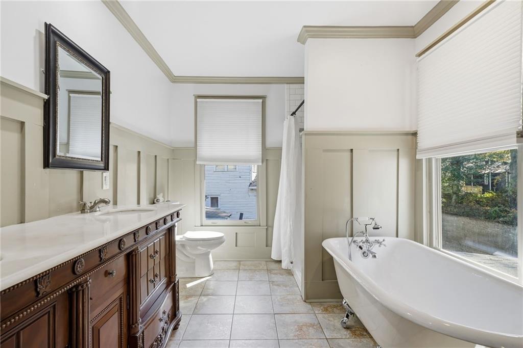 1530 South Gordon Street Southwest Atlanta, GA 30310 - Photo 31 of 46 a bathroom with a double vanity sink a toilet a mirror and bathtub