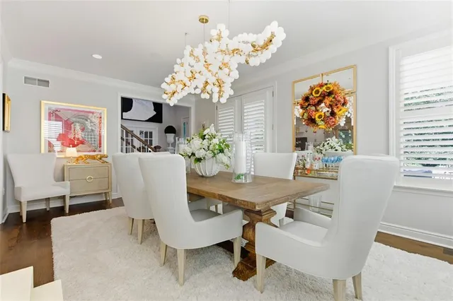 a view of a dining room with furniture a chandelier and wooden floor