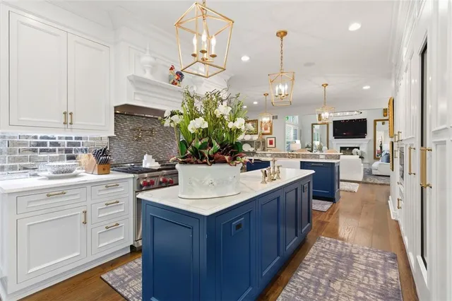 a large kitchen with kitchen island white cabinets and stainless steel appliances