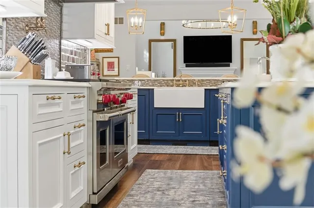a living room with stainless steel appliances furniture and a flat screen tv