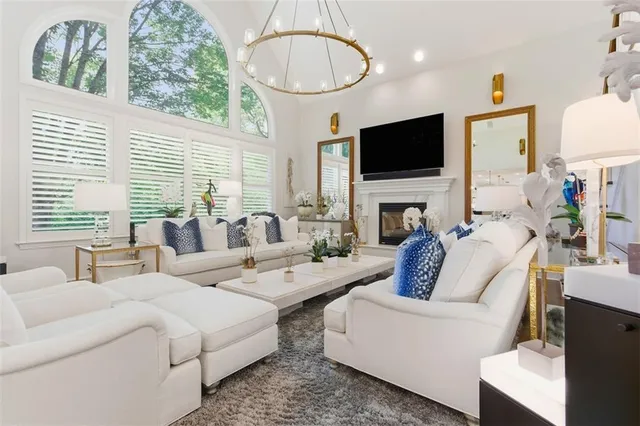 a living room with furniture a flat screen tv and a large window