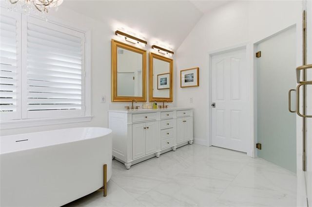 a bathroom with a tub sink and mirror