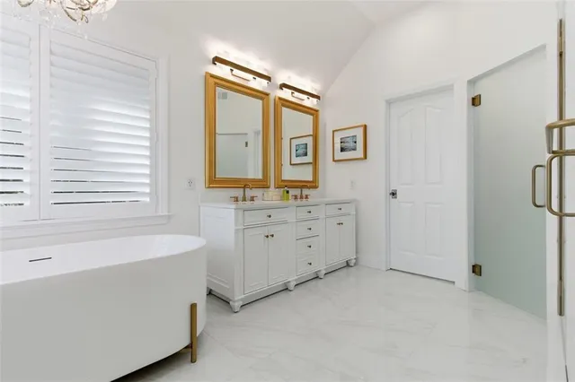 a bathroom with a tub sink and mirror