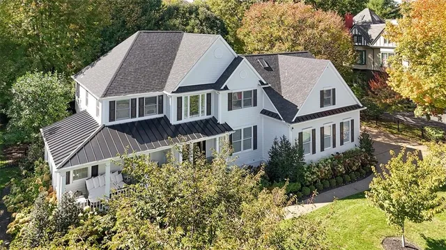 an aerial view of a house with yard and trees around