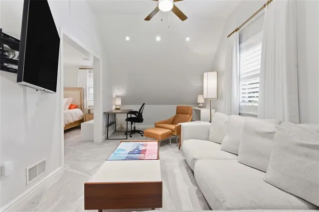 a living room with stainless steel appliances kitchen island granite countertop furniture and a flat screen tv