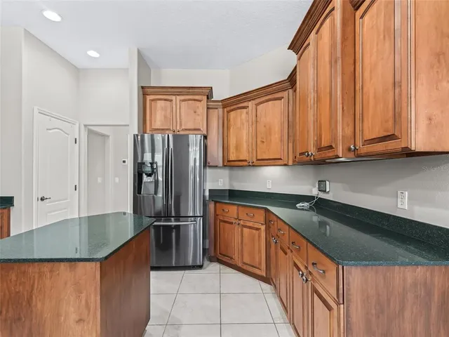 a kitchen with stainless steel appliances granite countertop a stove top oven a sink and a refrigerator