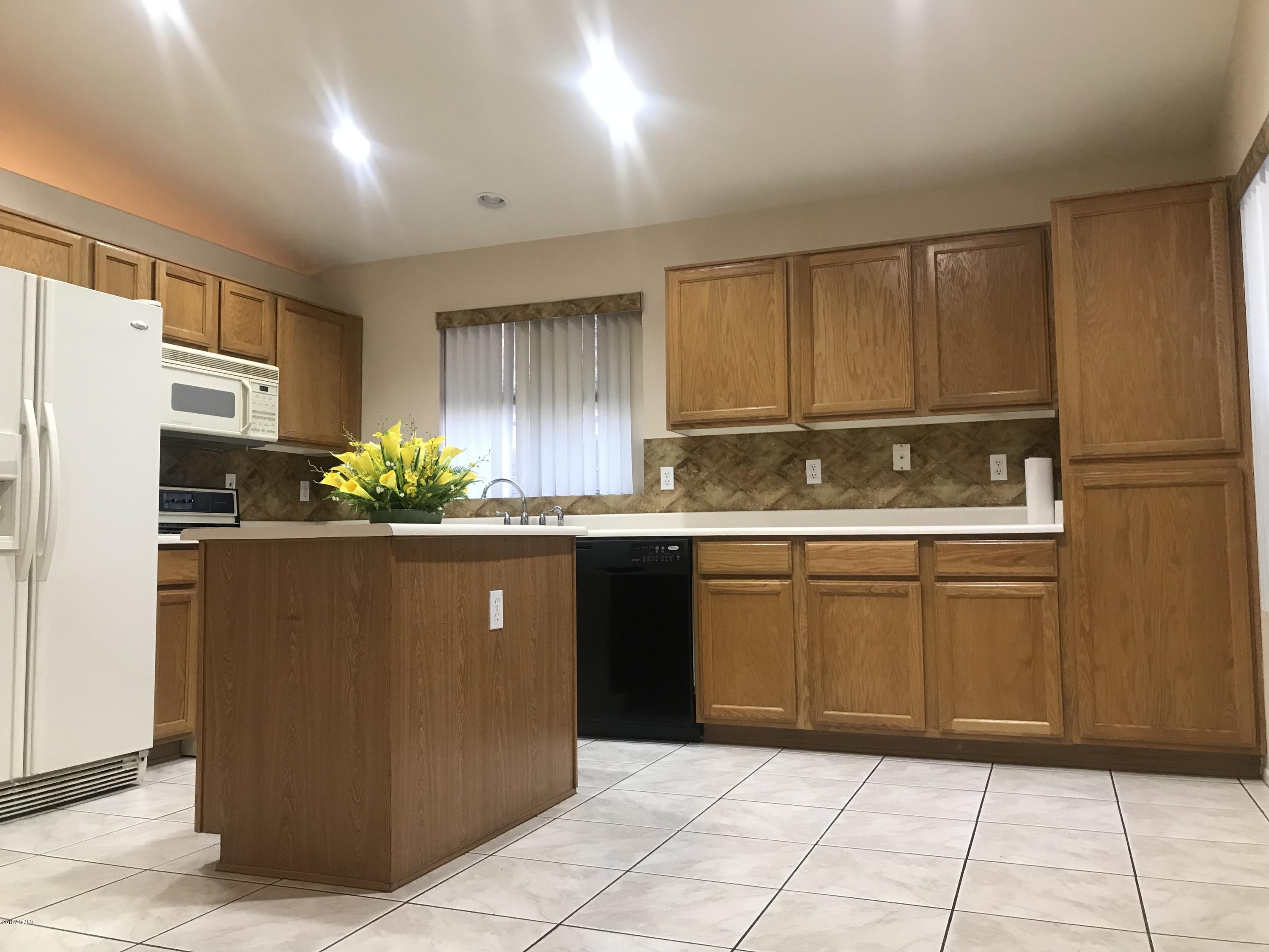 4133 West Bloomfield Road Phoenix, AZ 85029 - Photo 19 of 27 a kitchen with granite countertop cabinets and refrigerator