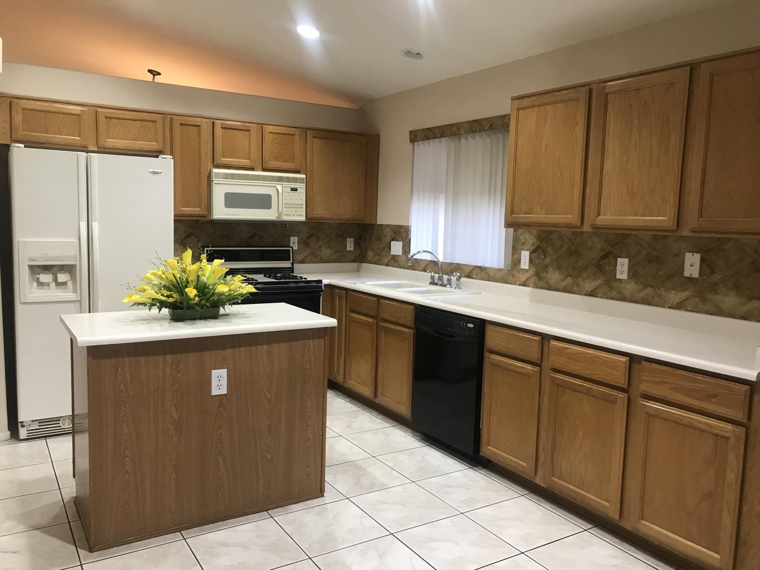 4133 West Bloomfield Road Phoenix, AZ 85029 - Photo 7 of 27 a kitchen with stainless steel appliances granite countertop a sink a counter space and cabinets