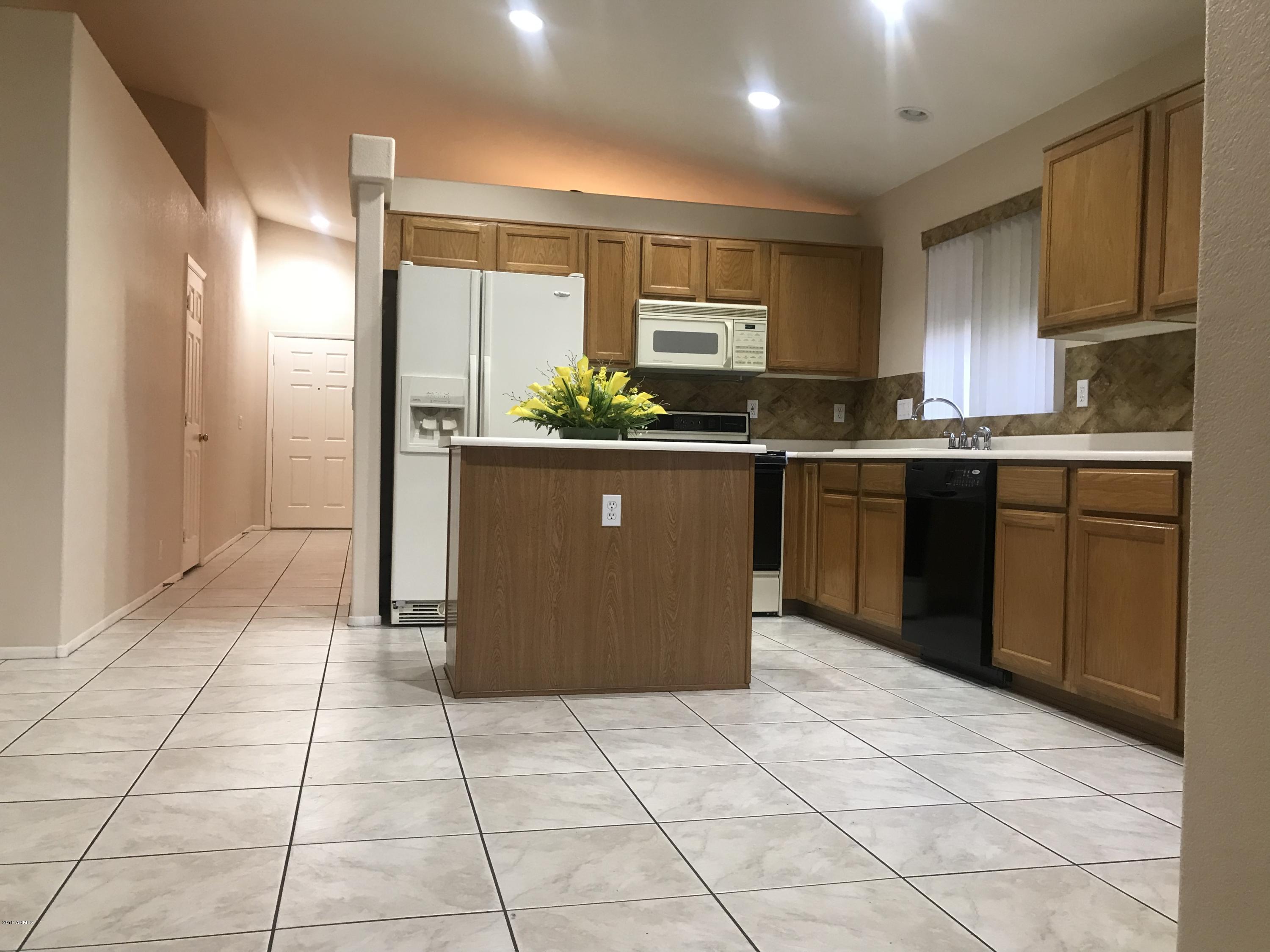 4133 West Bloomfield Road Phoenix, AZ 85029 - Photo 8 of 27 a large kitchen with granite countertop a stove a sink dishwasher and a refrigerator