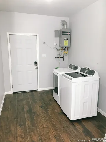 a utility room with wooden floor washer and dryer