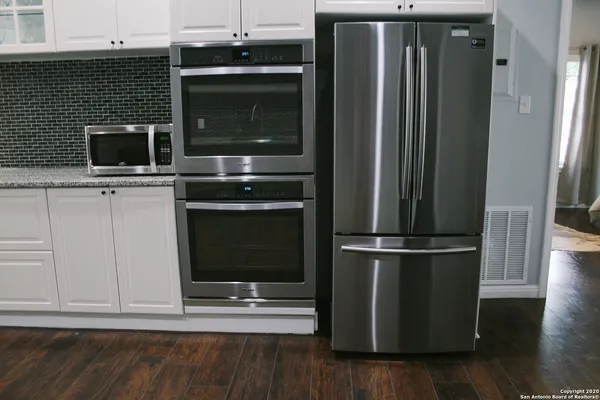 a kitchen with a refrigerator stove and cabinets