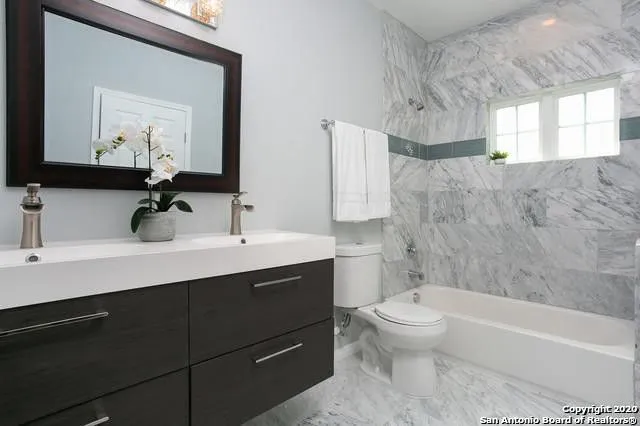 a bathroom with a sink a toilet and a mirror