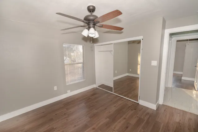an empty room with windows and fan