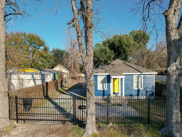a view of a brick house with large windows and a small yard