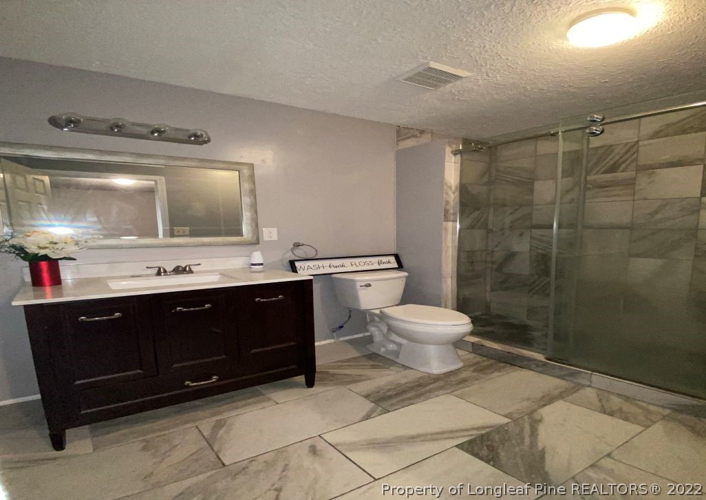 513 Andover Road Fayetteville, NC 28311 - Photo 13 of 21 a bathroom with a toilet a sink and mirror