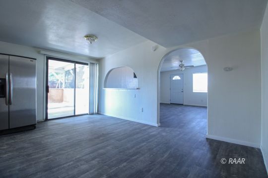 1645 Porter Street Ridgecrest, CA 93555 - Photo 9 of 35 an empty room with wooden floor and windows
