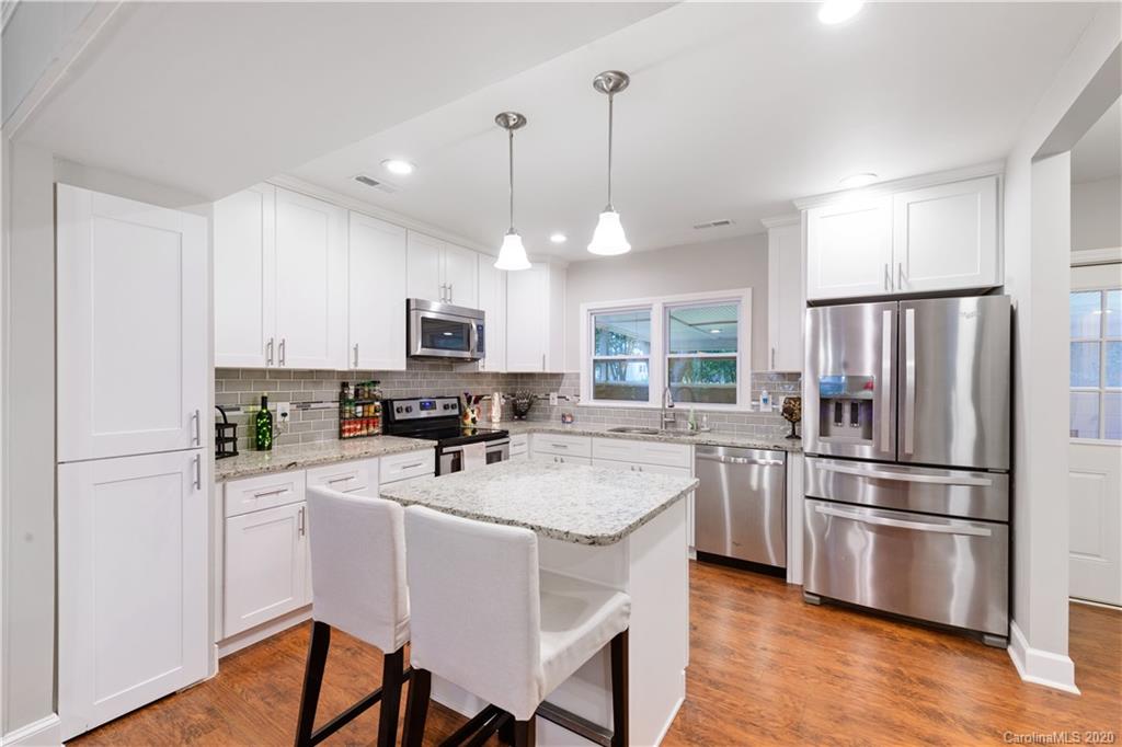 5600 Seacroft Road Charlotte, NC 28210 - Photo 5 of 18 a kitchen with refrigerator a stove a sink and white cabinets with wooden floor