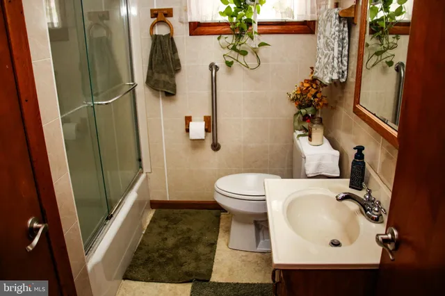 a bathroom with a sink and mirror with toilet