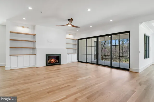 a large kitchen with stainless steel appliances kitchen island a large counter top and a wooden floor